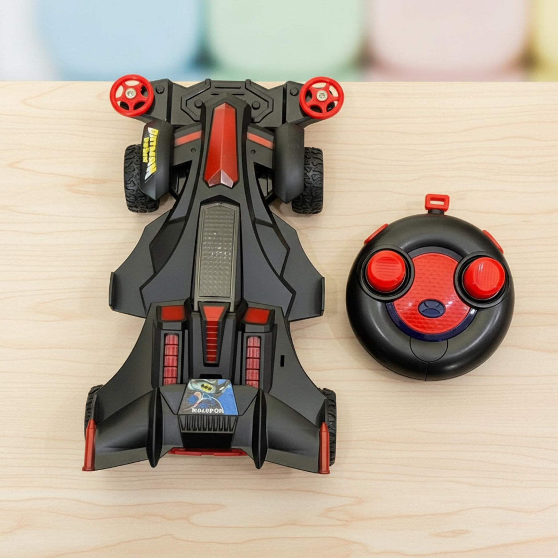 Toy car and remote control on a wooden surface