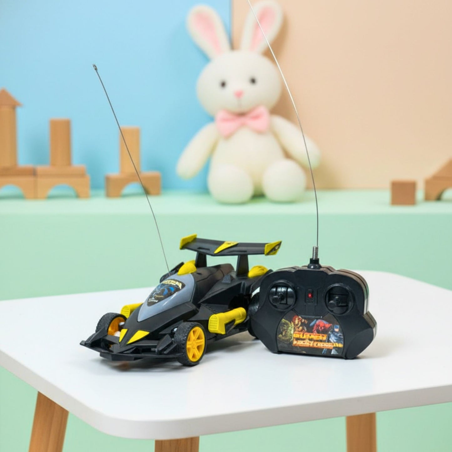 Toy race car with remote control on a table with a soft toy in the background