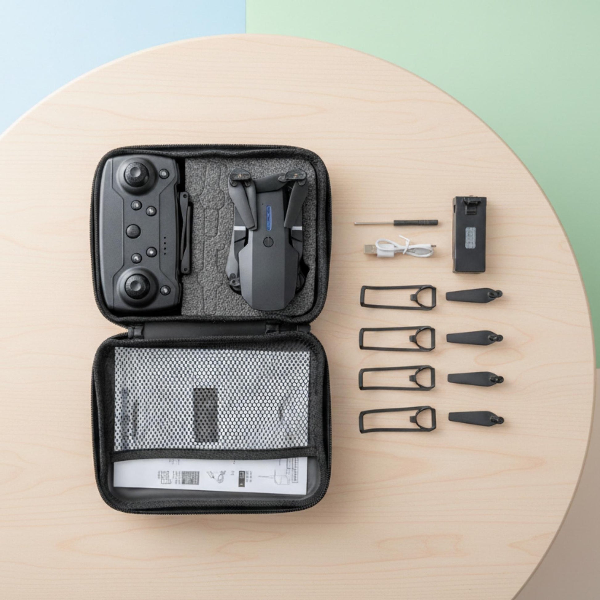 Set of tools and equipment in a black case on a wooden surface with a colorful background